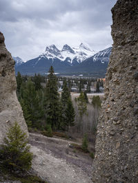 Three sisters mountain above canmore framed by hoodoos, shot at canmore, alberta, canada
