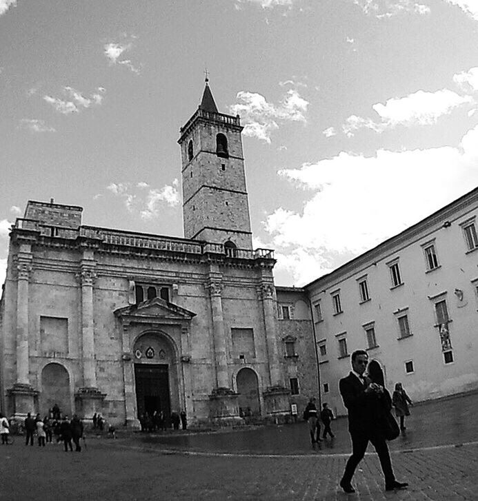 architecture, building exterior, built structure, sky, religion, church, place of worship, spirituality, history, low angle view, men, cloud, cloud - sky, facade, travel destinations, person, day