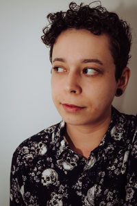 Close-up of woman looking away against wall