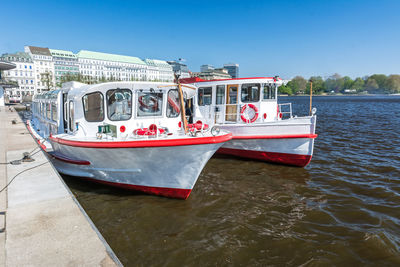 Red boat in river against blue sky