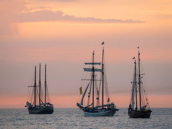 Nautical vessel on sea against sky during sunset