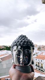 Portrait of person holding umbrella against sky