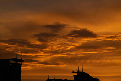 Low angle view of silhouette building against sky during sunset