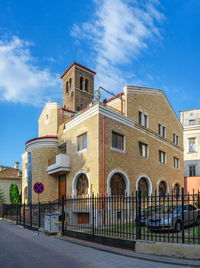 Building by road against sky in city