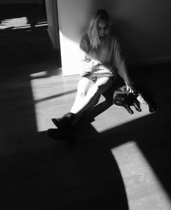 Portrait of young woman sitting on wall