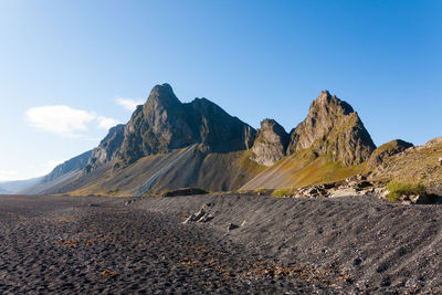 Panoramic view of rocky mountains against clear blue sky