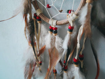 Close-up of dreamcatcher hanging by wall