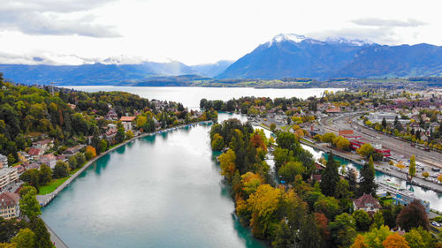 Scenic view of river by mountains against sky