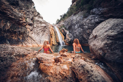 Group of people on rock against mountain