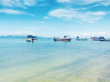 Boats sailing in sea against sky