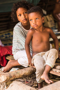 Portrait of shirtless boy sitting outdoors