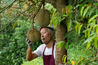 Full length of man standing on plant against trees