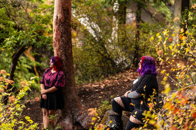 Rear view of women sitting in forest