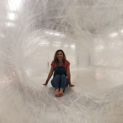 Full length portrait of young woman sitting in ice cave