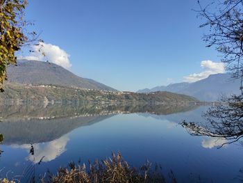 Scenic view of lake and mountains against blue sky