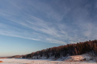 Scenic view of snow covered land against sky