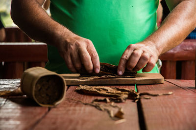 Close-up of man making cigar