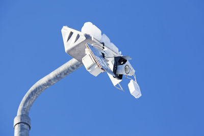 A street lamp that someone destroyed against blue sky