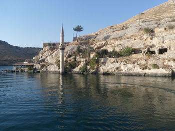 Scenic view of historic building by mountains against clear sky