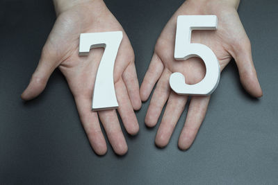 Midsection of woman holding text against black background