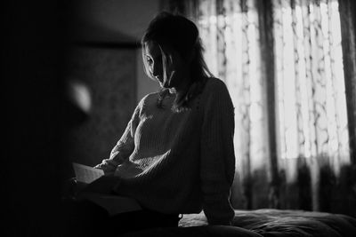 Young woman sitting on book