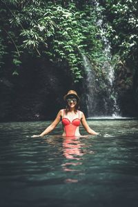 Portrait of young woman in water at forest