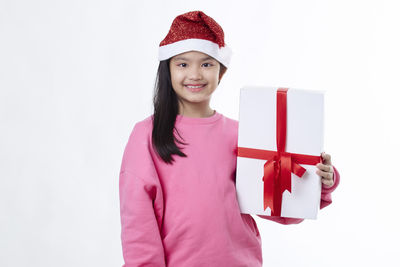 Portrait of a smiling young woman against white background