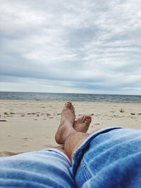 Low section of man lying on beach