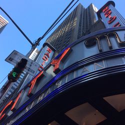 Low angle view of flags on building against sky