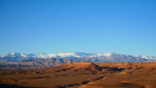 Scenic view of snowcapped mountains against clear blue sky