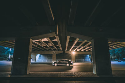 Bridge over car on illuminated road at night