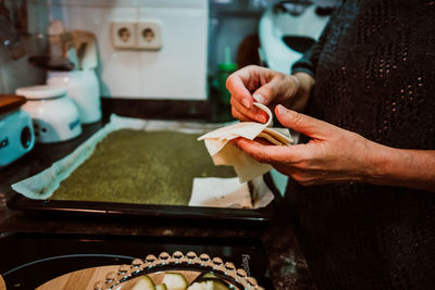 Midsection of woman preparing food at home