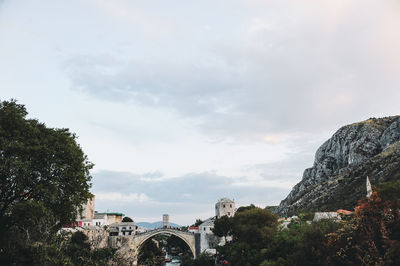 View of buildings in city against cloudy sky