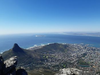 Aerial view of cityscape by sea against clear sky