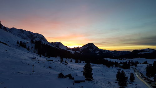 Scenic view of snow covered mountains against sky during sunset