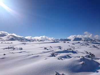 Scenic view of snow mountains against blue sky