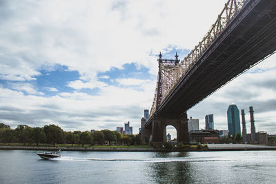 Jet ski passing crossing the hudson river below the brooklyn bridge in new york. 