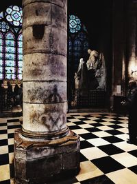 Buddha statue on tiled floor against building