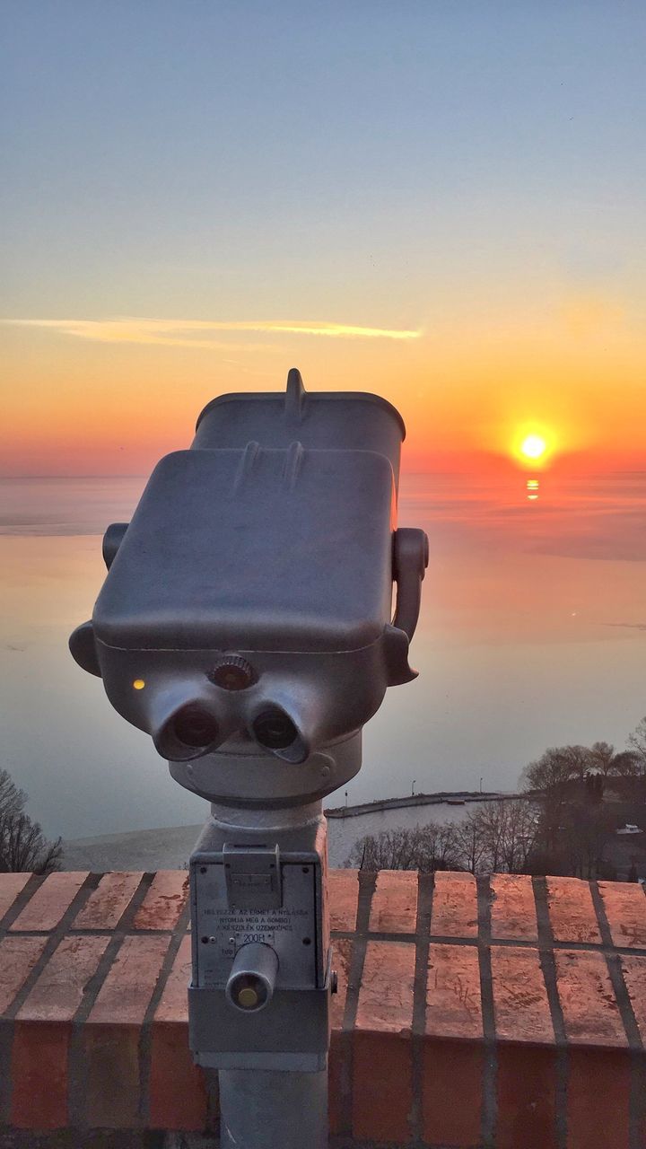 sunset, sea, sky, coin-operated binoculars, orange color, surveillance, scenics, outdoors, sun, beauty in nature, water, no people, telescope, nature, horizon over water, tranquil scene, hand-held telescope, tranquility, sunlight, beach, close-up, day