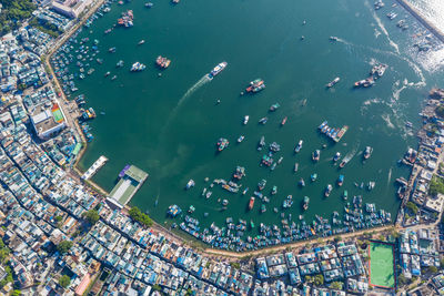 High angle view of illuminated city by sea