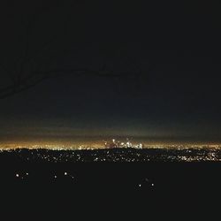 Illuminated city against sky at night