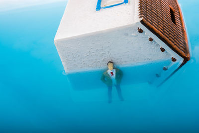 Close-up of model home with male figurine in swimming pool