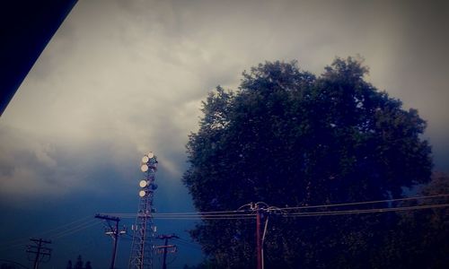 Low angle view of power lines against cloudy sky