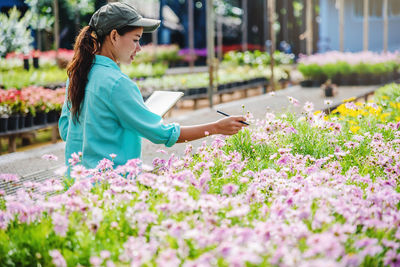 Side view of woman holding flowering plants