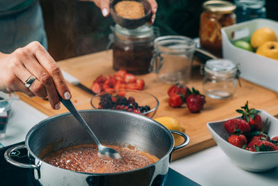 Fruit canning preservation. woman cooking fruits and making homemade jam.