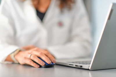 Detail of health care hand controlling computer mouse to write diagnosis