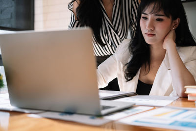 Businesswomen looking at laptop in office