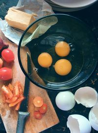 Close-up of egg yolk in bowl by cutting board