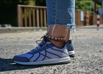 Low section of woman wearing shoes standing outdoors