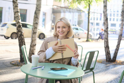 Young woman using laptop while sitting on chair